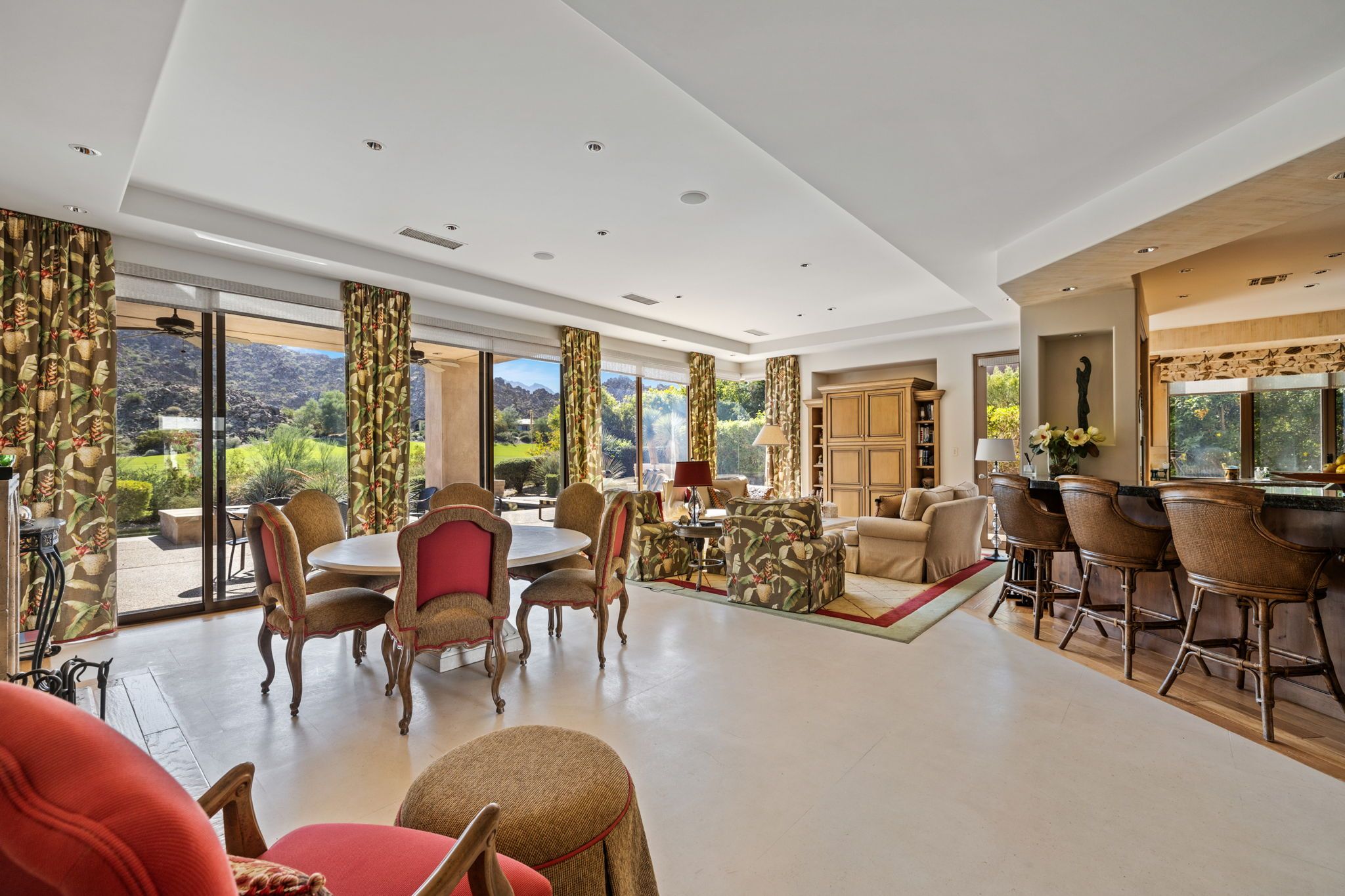 A spacious living area with a dining table, multiple chairs, a sofa, and a bar area.