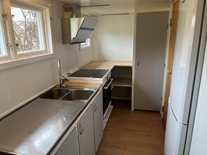 A compact kitchen with a stainless steel sink, a wooden countertop, and a built-in oven. - Charming Country House - Bedding and towels included. 5 minutes from the Öland Bridge. (Färjestaden)