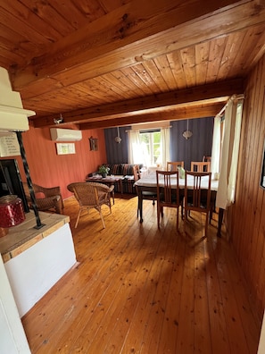 A wooden interior with a dining area, a sofa, and a table.