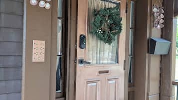 A brown door with a wreath, a mailbox, and a doorbell.