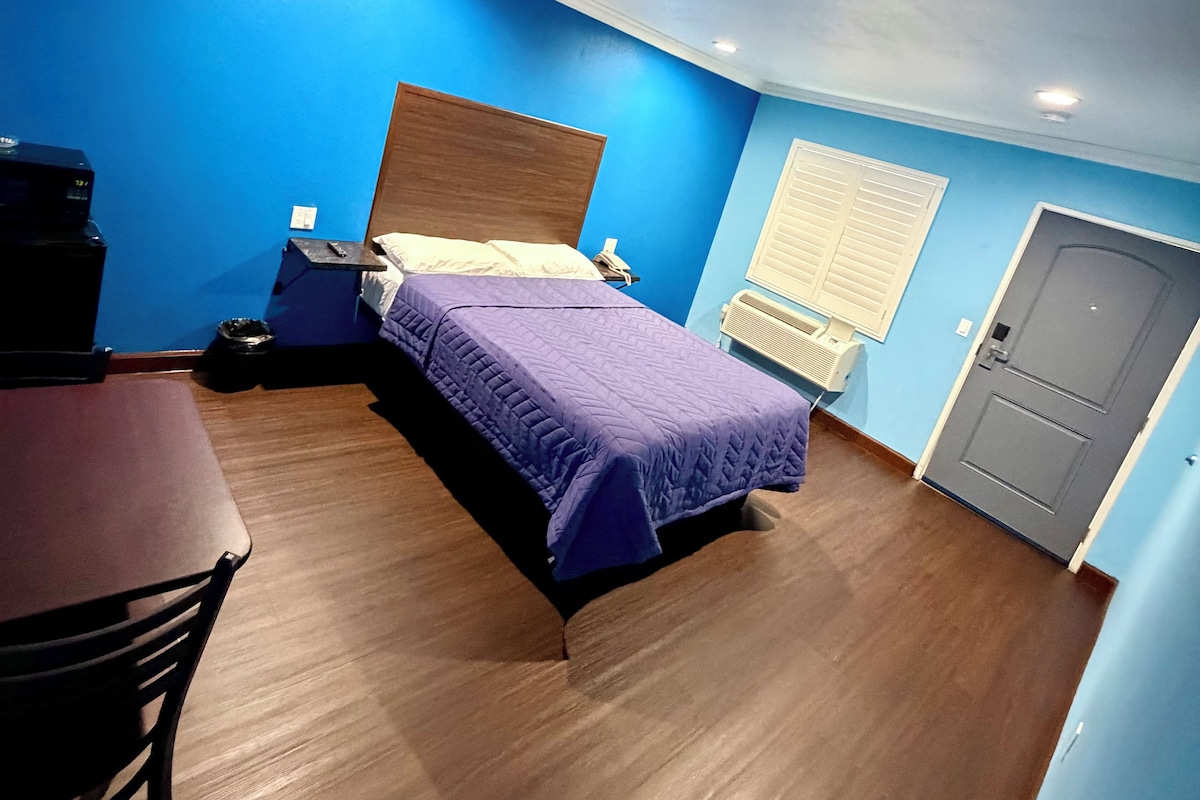 A room with a bed, a desk, and a chair.