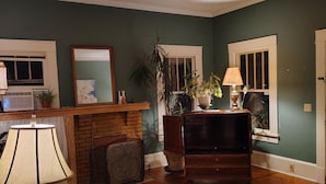 Una sala de estar con chimenea, televisor y comedor con mesa y sillas.