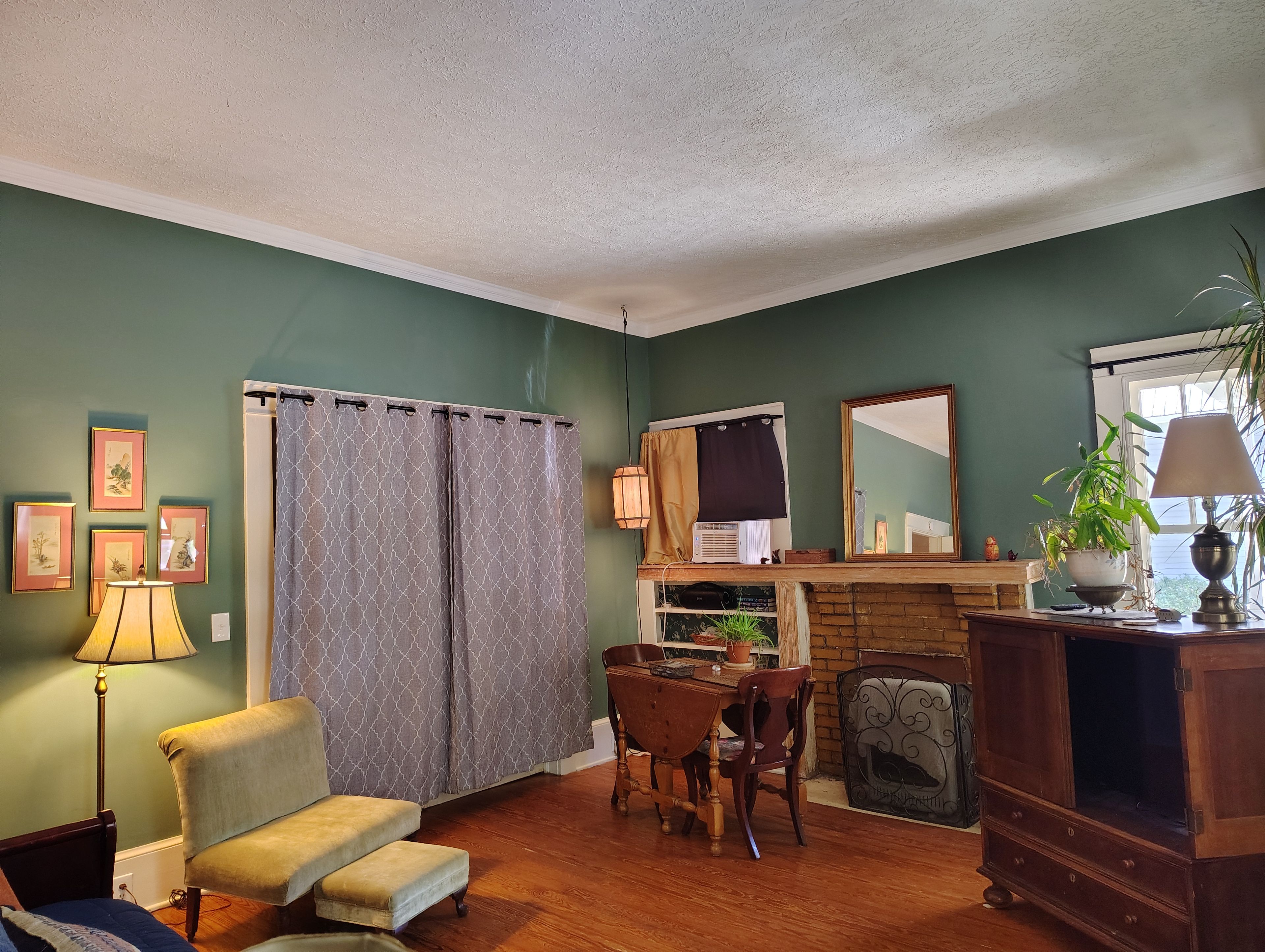 A living room with a fireplace, a dining table with chairs, a sofa, and a television set.