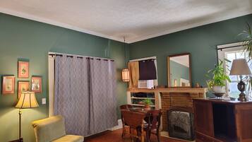 A living room with a fireplace, a dining table with chairs, a sofa, and a television set.
