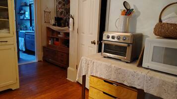 Une cuisine équipée d’un four à micro-ondes, d’un four traditionnel et d’un meuble en bois.