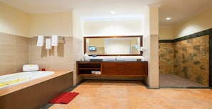 A modern bathroom with a large bathtub, a wooden vanity, a mirror, and a stone wall. - Cozzy Intan Legian Seminyak Villa (Badung)