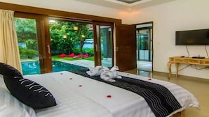 Una habitación de hotel con una cama, un televisor y vistas a la piscina.