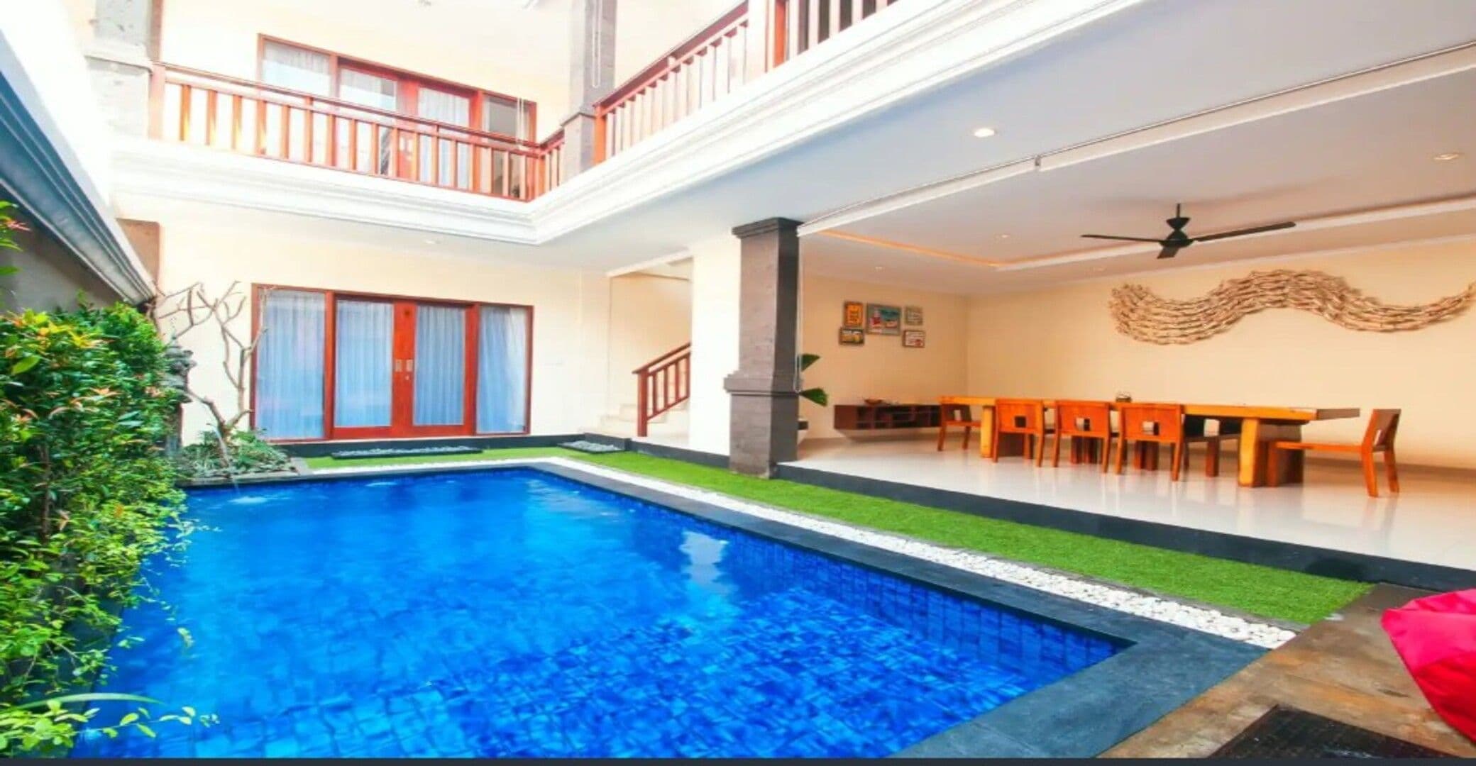 Ein mehrstöckiges Wohngebäude mit Schwimmbad, Essbereich und Treppe.
