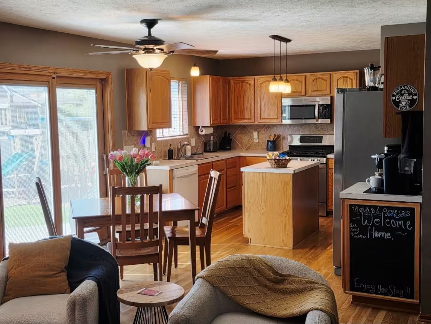 Una cocina moderna con armarios de madera, una isla central y un refrigerador con cafetera.