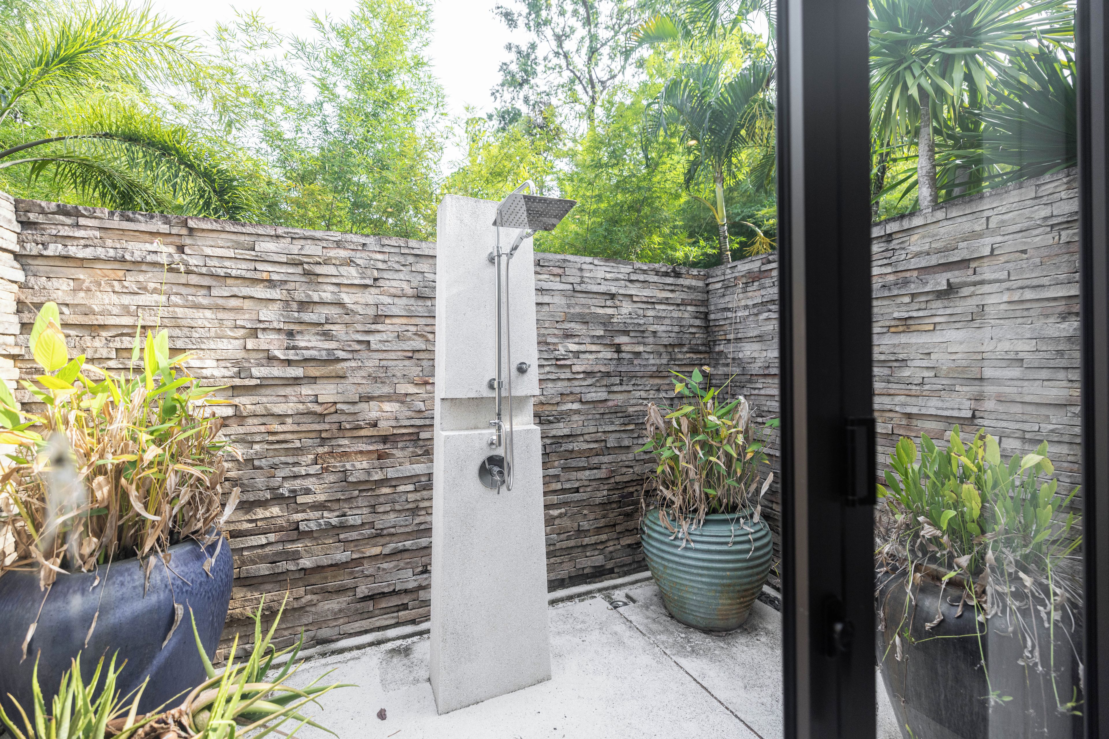 A stone wall with a built-in showerhead.