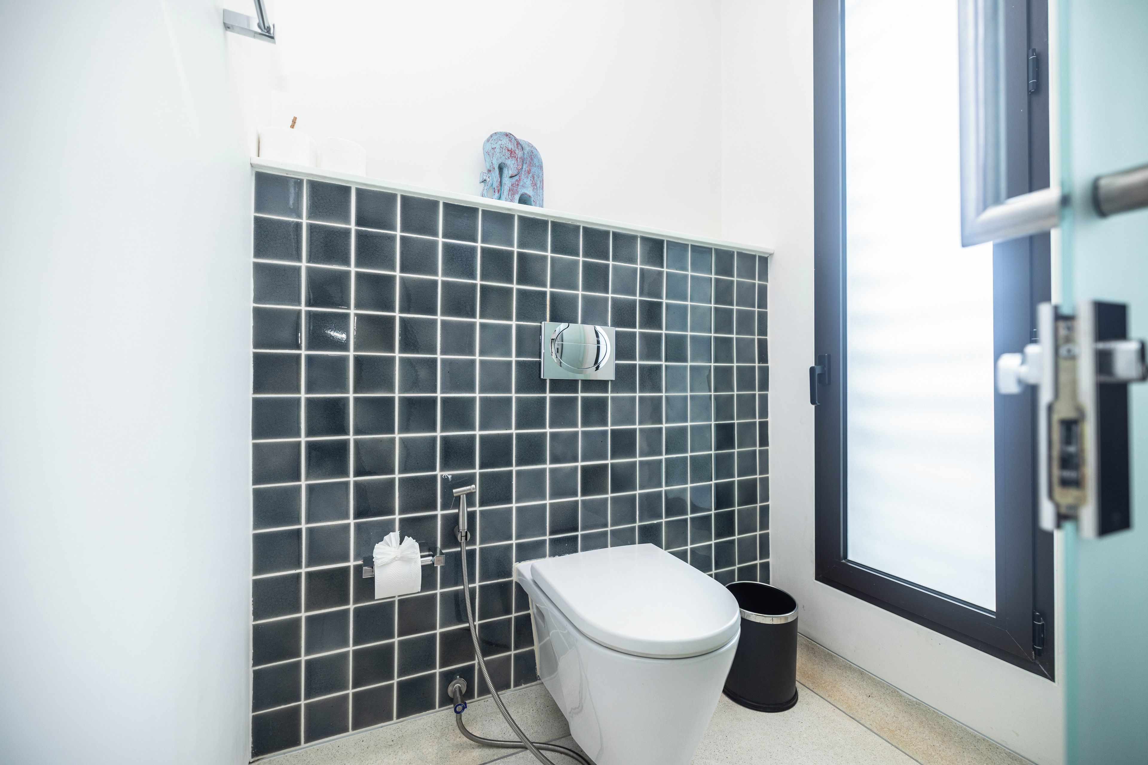 Un baño moderno con inodoro, bidé y un cubo de basura.