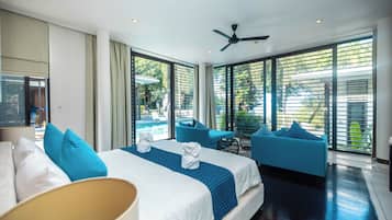 Ein Hotelzimmer mit einem Bett, einer Couch, einem Deckenventilator und großen Fenstern.