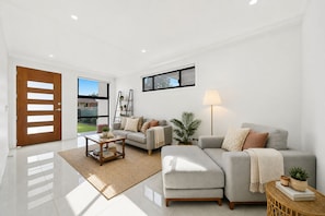 A modern living room with a sofa, coffee table, and a lamp.