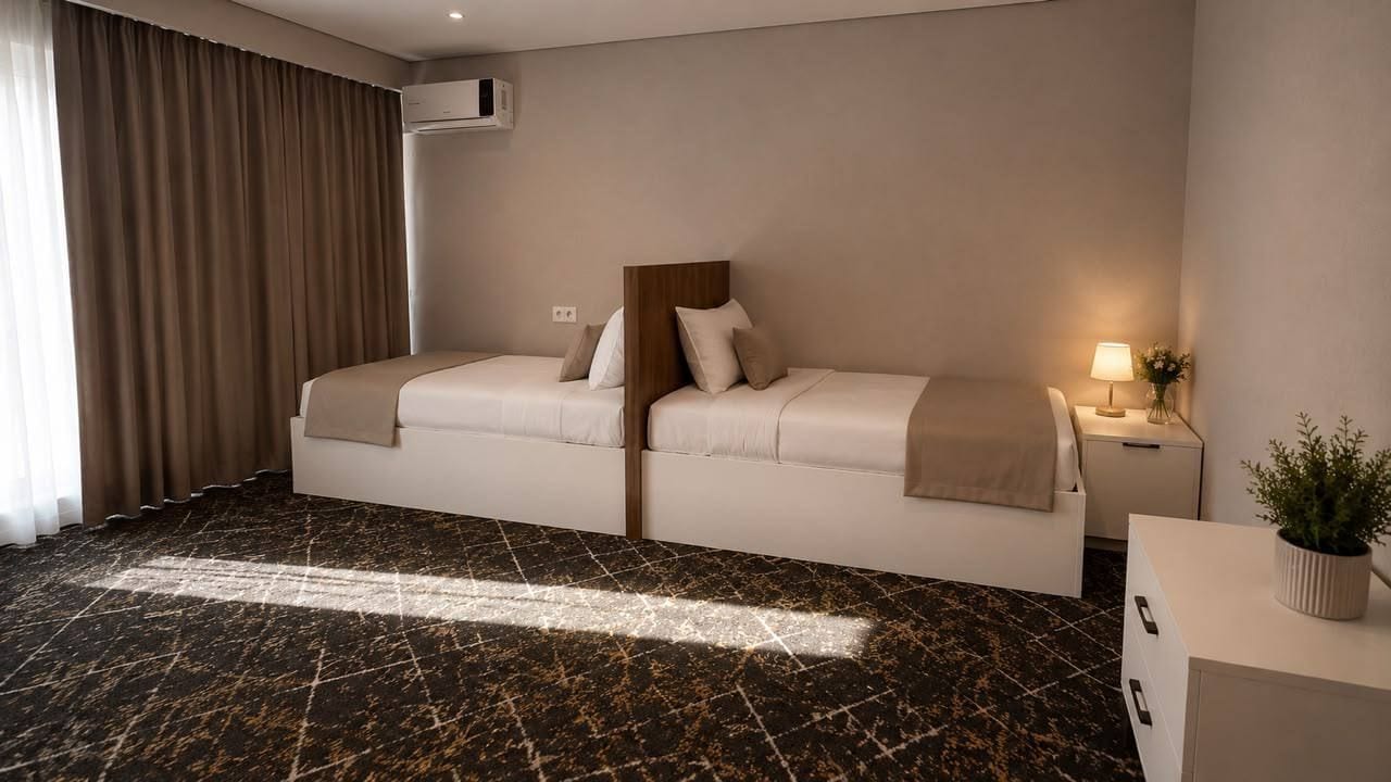Une chambre d’hôtel avec un lit, une table de chevet, une lampe et une plante en pot.