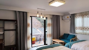 Habitación de hotel con cama, sofá, mesa y balcón.