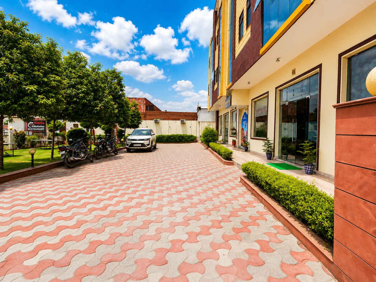 A paved walkway leading to a building with a sign for a restaurant.