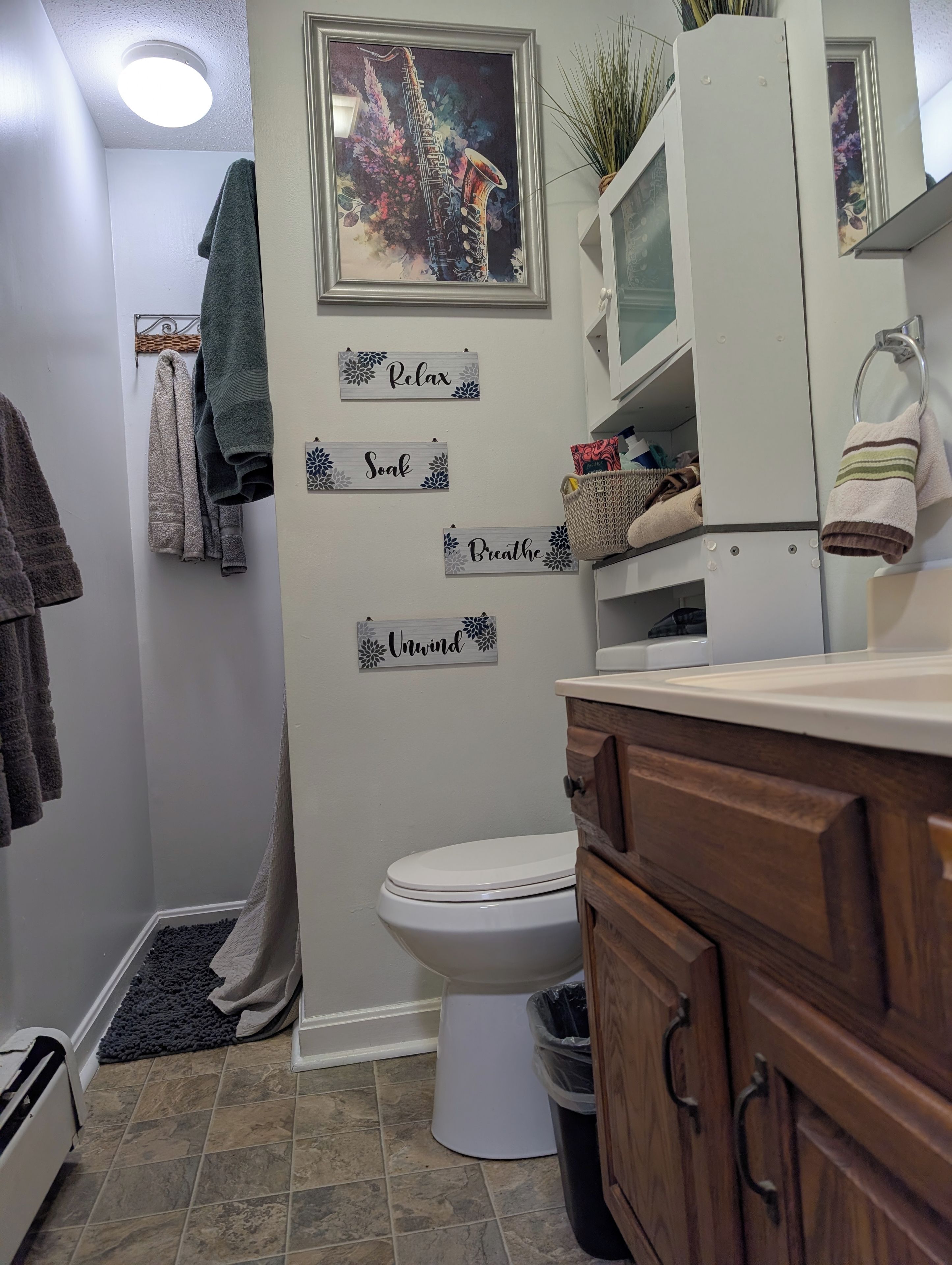 A bathroom with a toilet, a sink, a mirror, and a towel rack.