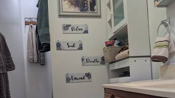 A bathroom with a toilet, a sink, a mirror, and a towel rack.
