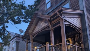 A two-story house with a balcony, a staircase, and a garden area. - 146-2 Satchmo, Louie Armstrong. Chocolatey Jazz Lounge w/Mini Rolling Desk. (New London)