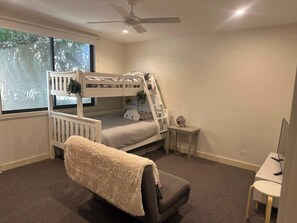 A bunk bed with a ladder, a small bedside table, a chair, and a desk with a computer. - Wye Not  Panorama Ocean Views (Wye River)