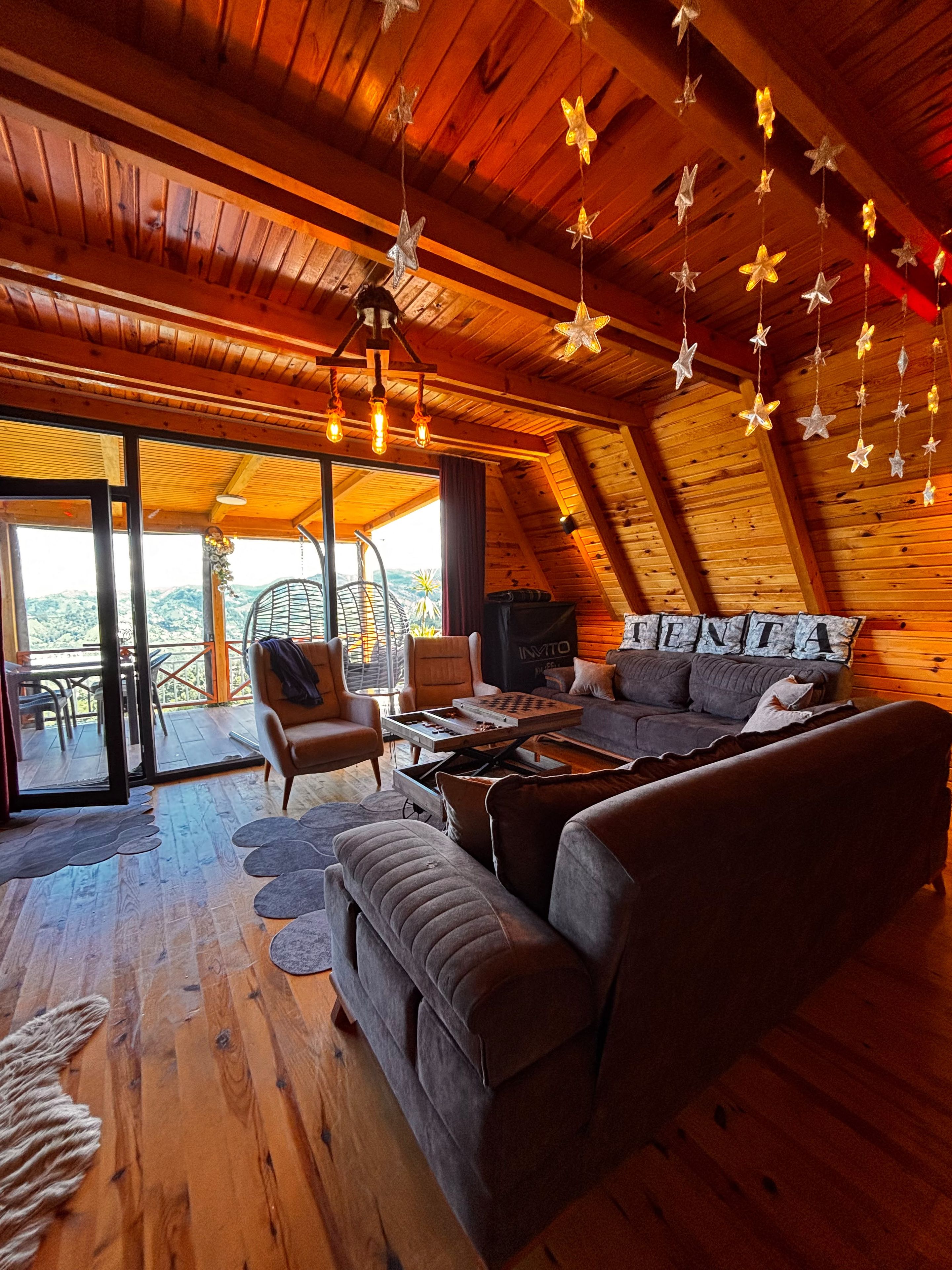 A cozy, wooden-floored living room with a sofa, armchairs, and a coffee table.
