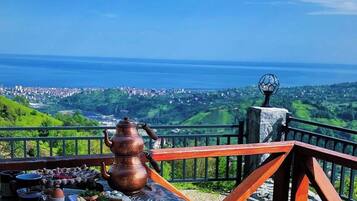A table set with a variety of food items and a view of a coastal landscape.