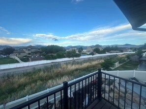 A residential area with houses, a fenced pathway, and a clear sky. - Serene Mountain & Temple View Retreat w/ Hot Tub Access (Riverton)