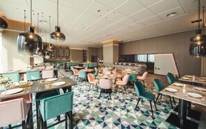 A modern dining area with multiple tables and chairs, a patterned floor, and pendant lighting. - Chengdu MUSTEL Muwenti Hotel (Chengdu)