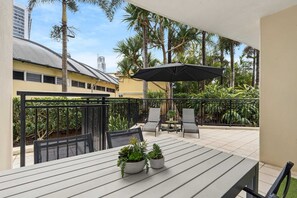 A balcony with a table, chairs, and potted plants. - The Courtyard at Chevron - Surfers Paradise (Surfers Paradise)