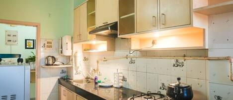 A kitchen with a gas stove, cabinets, and a refrigerator.