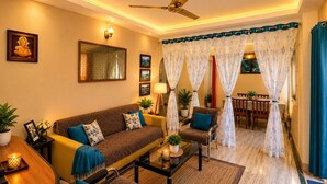 A living room with a sofa, armchairs, a coffee table, and a dining area with a table and chairs. - Rooftop Cityscape Inn || Luxurious 3BHK Apartment || Cityview (Guwahati)