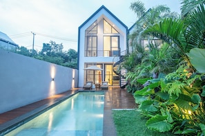 A modern house with a swimming pool, a covered outdoor seating area, and lush greenery. - 2BR Ocean View Pool Villa in Nusa Dua (Nusa Dua)