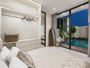 A bedroom with a bed, bedside table, and a view of an outdoor swimming pool. - Casa Rio 3BR Enclosed Living & Pool (Keroboken Kelod)