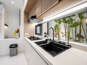 A modern kitchen with a double sink, a stove, and a range hood. - Casa Rio 3BR Enclosed Living & Pool (Keroboken Kelod)