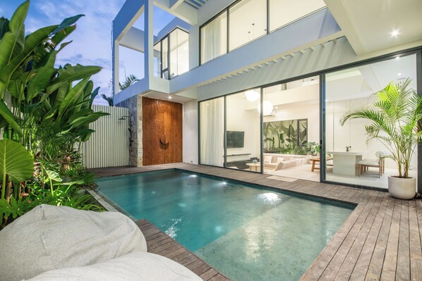 A modern house with a swimming pool, a patio with outdoor furniture, and a large glass door leading to an interior space. - Casa Rio 3BR Enclosed Living & Pool (Keroboken Kelod)
