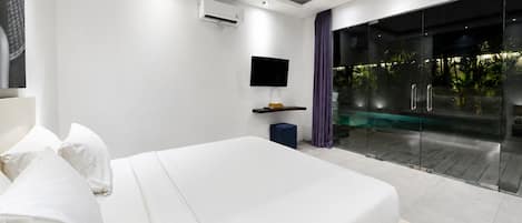 A modern bedroom with a large bed, a flat-screen TV, an air conditioning unit, and a glass door leading to an outdoor area.
