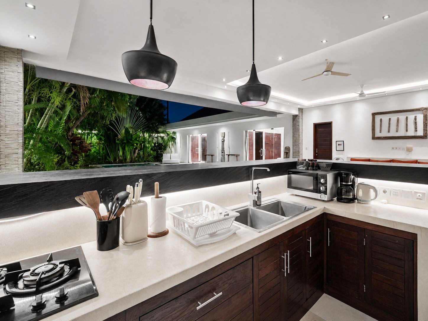 A modern kitchen with a gas stove, a sink, and a coffee maker.