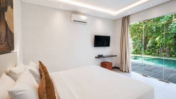 Un dormitorio moderno con una cama grande, un televisor de pantalla plana, un equipo de aire acondicionado y vista a una piscina.