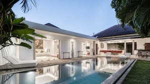 A modern house with a swimming pool, a covered patio, and a well-maintained lawn. - Villa Saha Elegant 3BR Pool Oasis Seminyak (Seminyak)