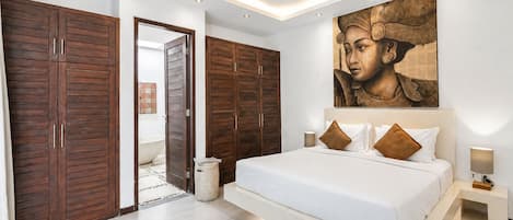 A modern bedroom with a large bed, wooden wardrobes, and a large painting on the wall.