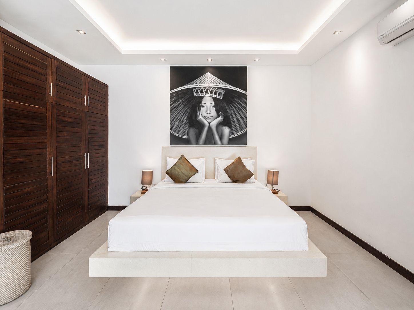 A modern bedroom with a large bed, wooden wardrobe, and a wall-mounted artwork.