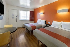 A hotel room with two beds, a desk, and a chair. - 2 Queen Beds | Smoking (Claremont)
