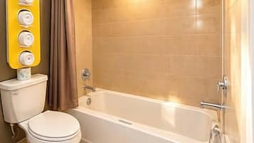 A bathroom with a toilet, bathtub, and a shower.