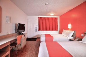 A hotel room with a desk, two beds, a television, and a red curtain. - Spacious room, 2 double beds | Accessible/Bathtub (Saint Joseph)