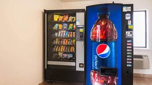 Un distributeur automatique arborant le logo Pepsi, avec un autre distributeur, cette fois pour les collations, placé à côté.