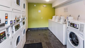 A laundry facility with multiple washing machines and dryers, a tiled floor, and a green wall. - 2Full Bed Non-Smoking|Jacksonville (Jacksonville)