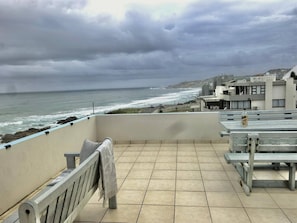 Een balkon met uitzicht op de zee en een stadsgezicht.