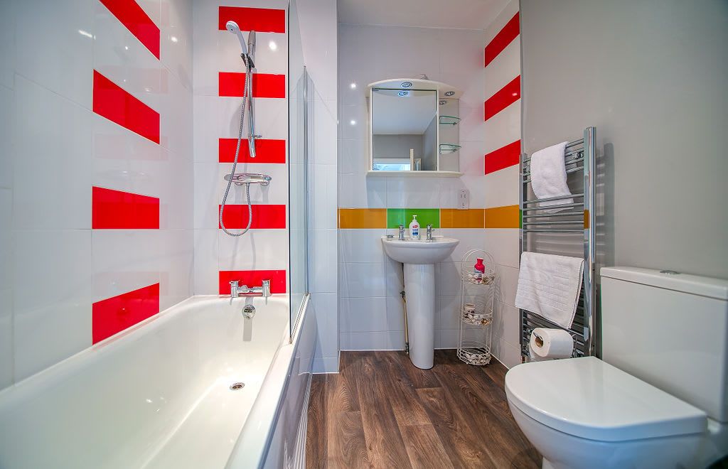 A modern bathroom with a bathtub, sink, and toilet.