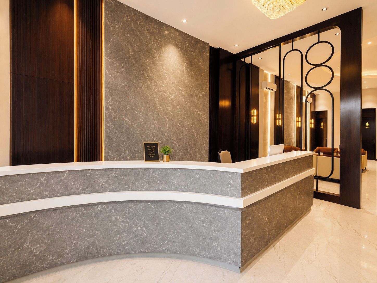 A reception desk with a marble countertop, a welcome sign, and a potted plant.