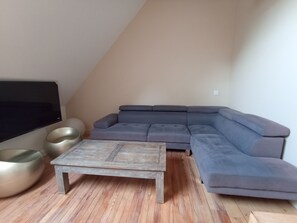 A living room with a sectional sofa, a flat-screen TV, a coffee table, and a large decorative bowl. - Maison Quend Plage maison de 14 pers en Baie de Somme 4 salles de bains 3 WC (Quend)